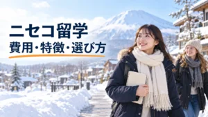 雪のニセコで教材を持ち、外国人学生と歩く日本人女性留学生